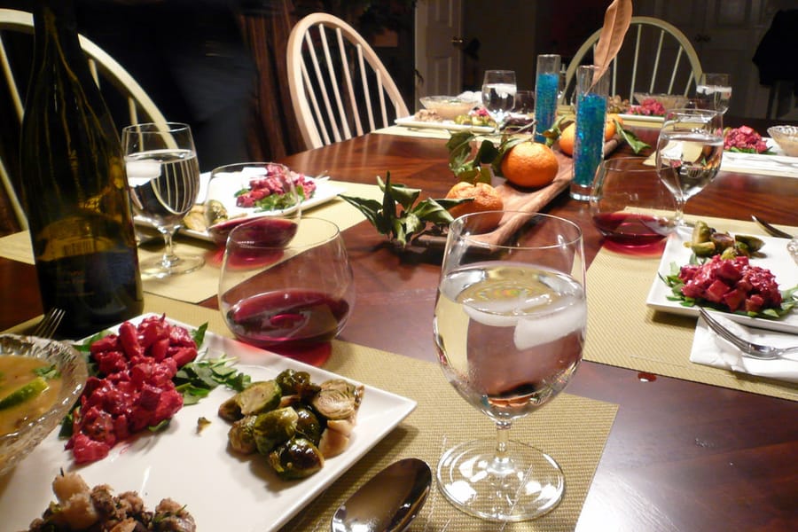 Table dressée pour un dîner de gala avec nappe blanche et verrerie